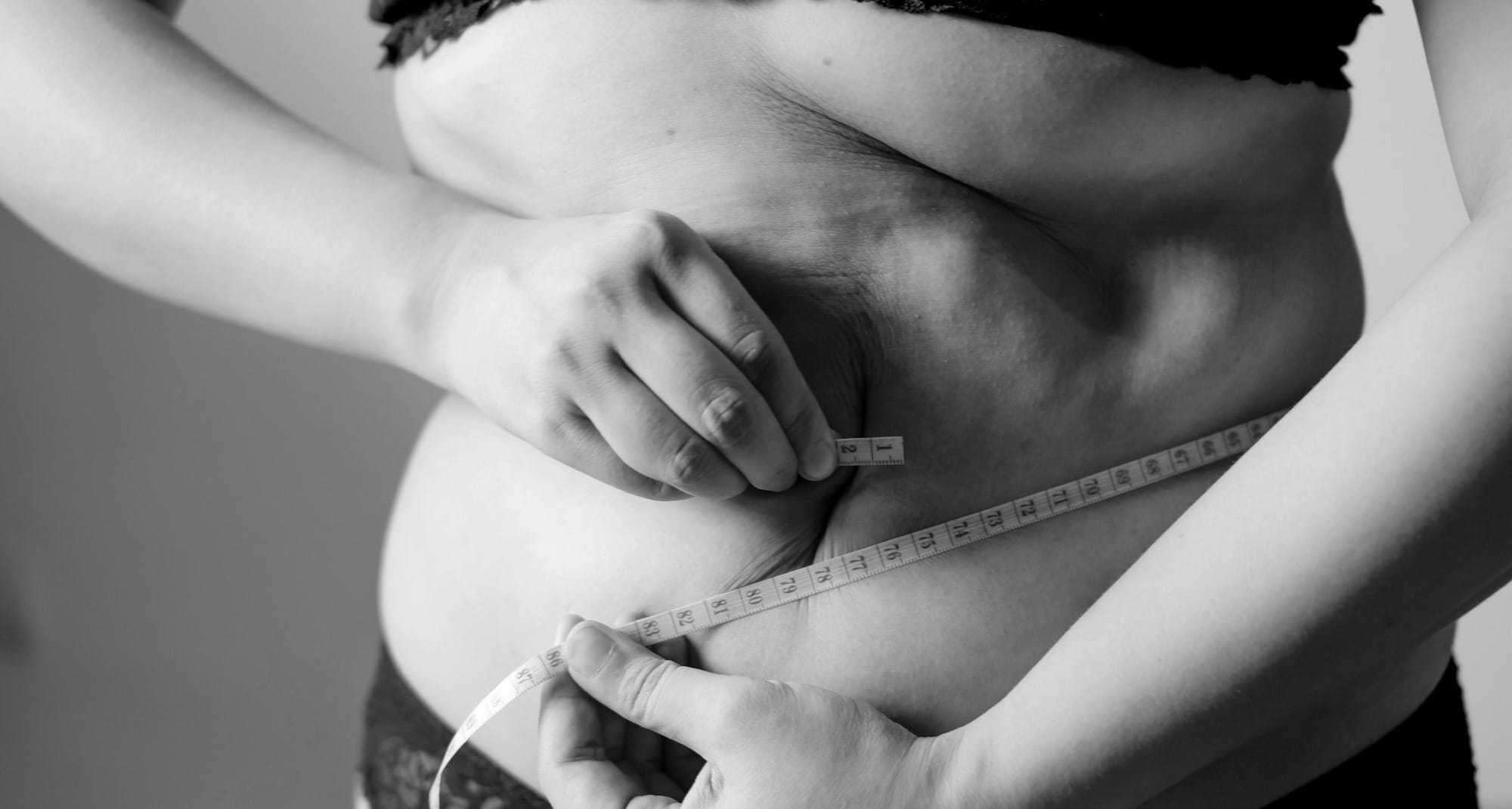 grayscale photo of woman holding her breast