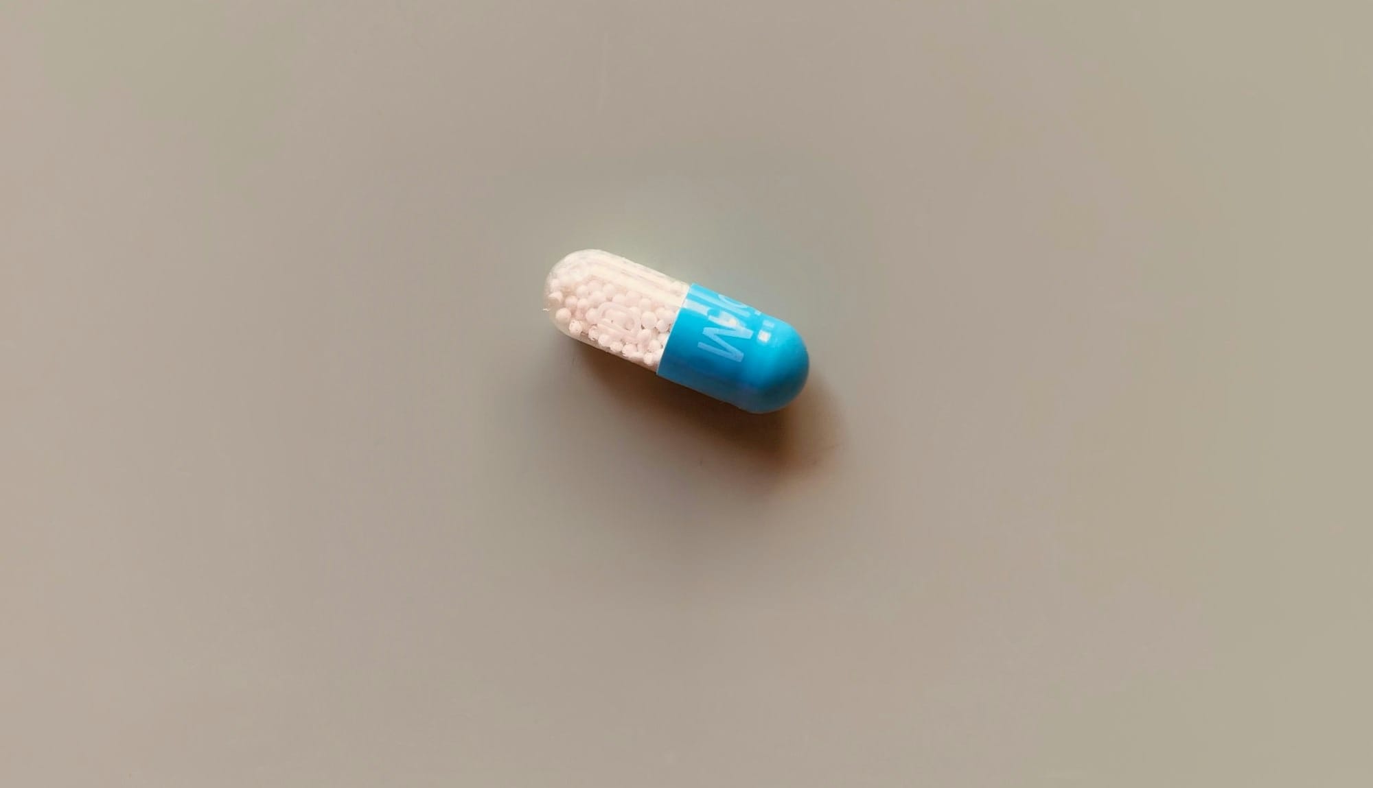a blue and white pill sitting on top of a table